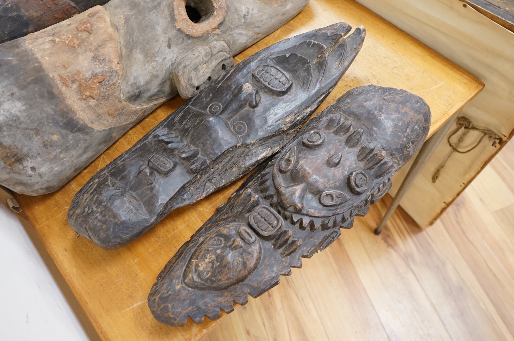 Papua New Guinea Septik River, a collection of five similar carved wooden masks of elongated form, applied in places with shells and two smaller masks with double face carving. Largest 80cm high.